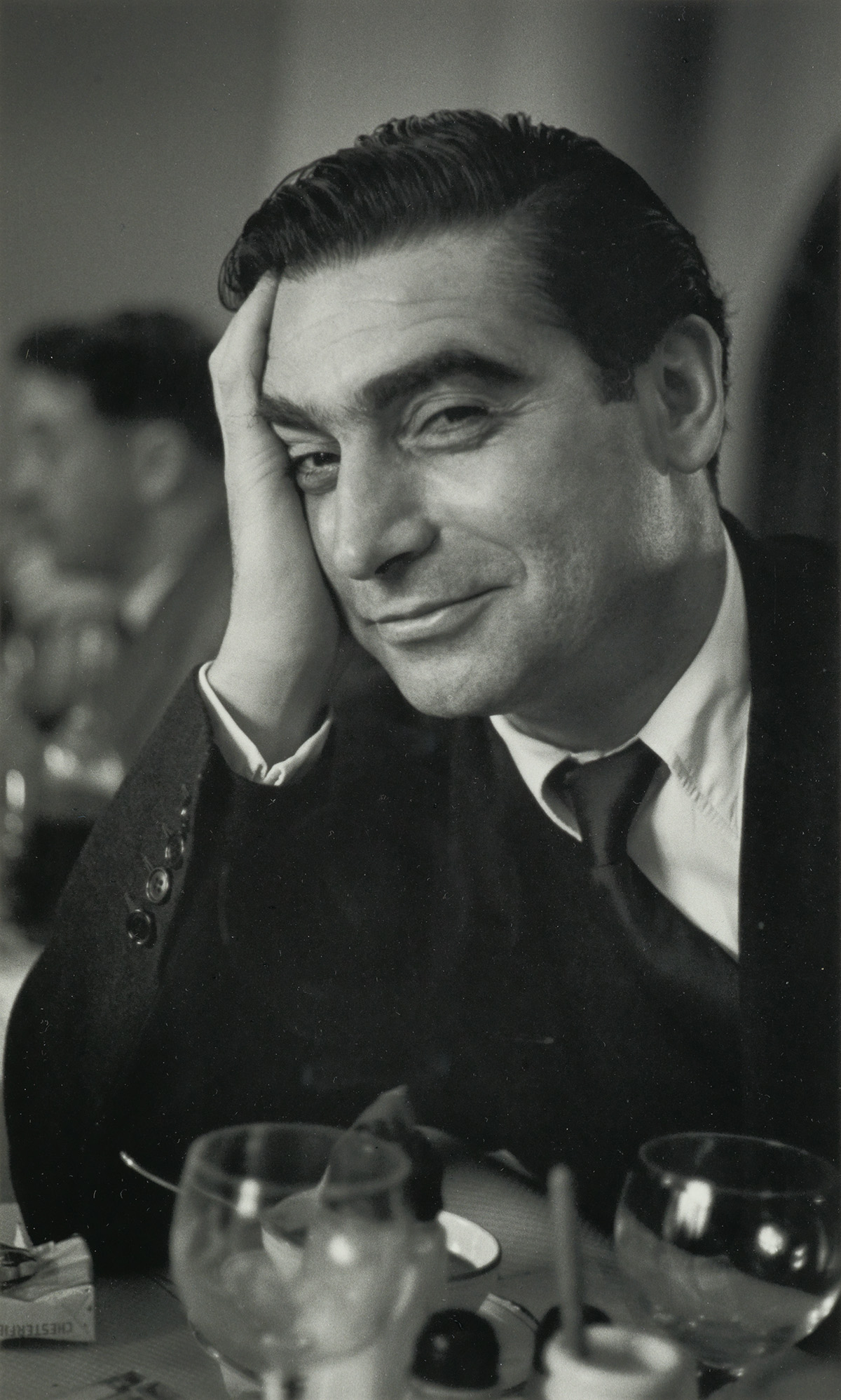 RUTH ORKIN (1921-1985) Robert Capa at Magnum luncheon, Paris.